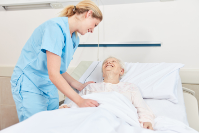 Nurse cares caring for bedridden senior citizen in the hospital bed